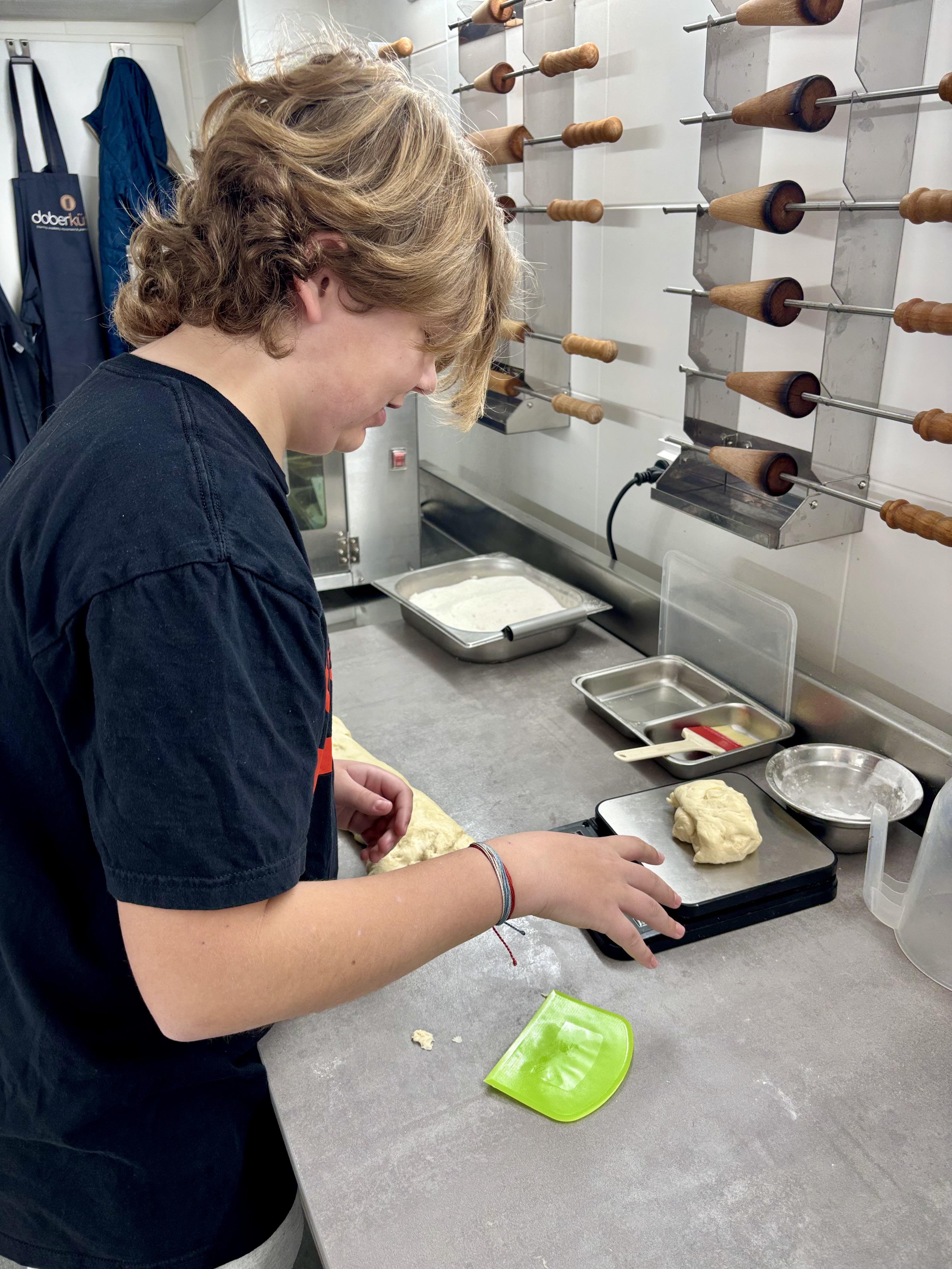 Caleb learning to weigh and prepare chimney cake dough at Kürtős Academy